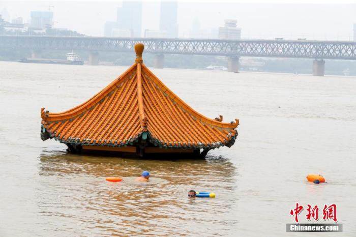 7月10日,湖北武汉,市民游泳经过被洪水淹没的黄花叽亲水平台。受近期强降雨影响,长江中下游干流及两湖出口控制站水位持续上涨,超出警戒水位。<a target='_blank' href='http://www.chinanews.com/'>中新社</a>记者 张畅 摄 点击进入下一页