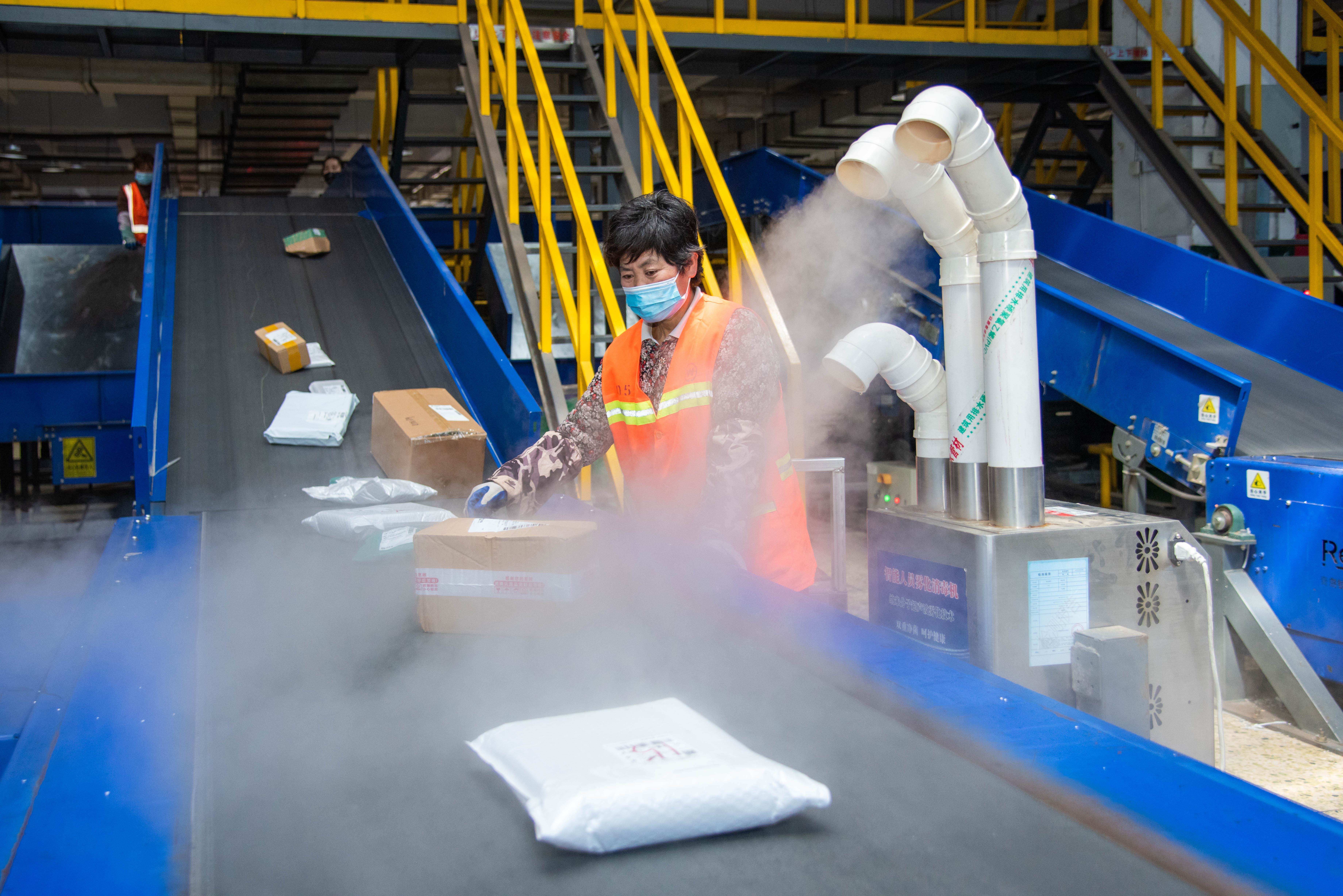 雾化消毒器对传送带上的快递进行六面消杀