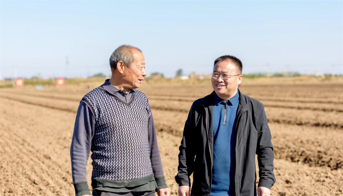 2021年10月22日,张万里(右)与当地老粮王孙丰忠在田间交流